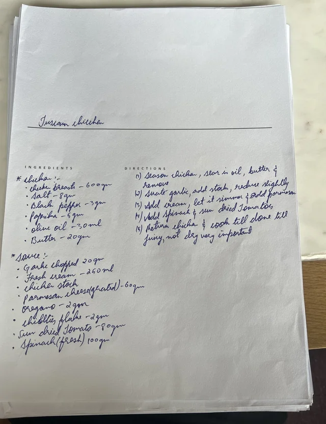 The chef’s handwritten Tuscan Chicken sheet. Chicken: chicken breasts 600 g, salt 8 g, black pepper 3 g, paprika 5 g, olive oil 30 ml, butter 20 g. Sauce: garlic chopped 20 g, fresh cream 250 ml, chicken stock with no amount, parmesan cheese grated 60 g, oregano 2 g, chilli flakes 2 g, sun-dried tomato 80 g, spinach 100 g. Five directions, ending: cook till done, juicy, not dry, very important.